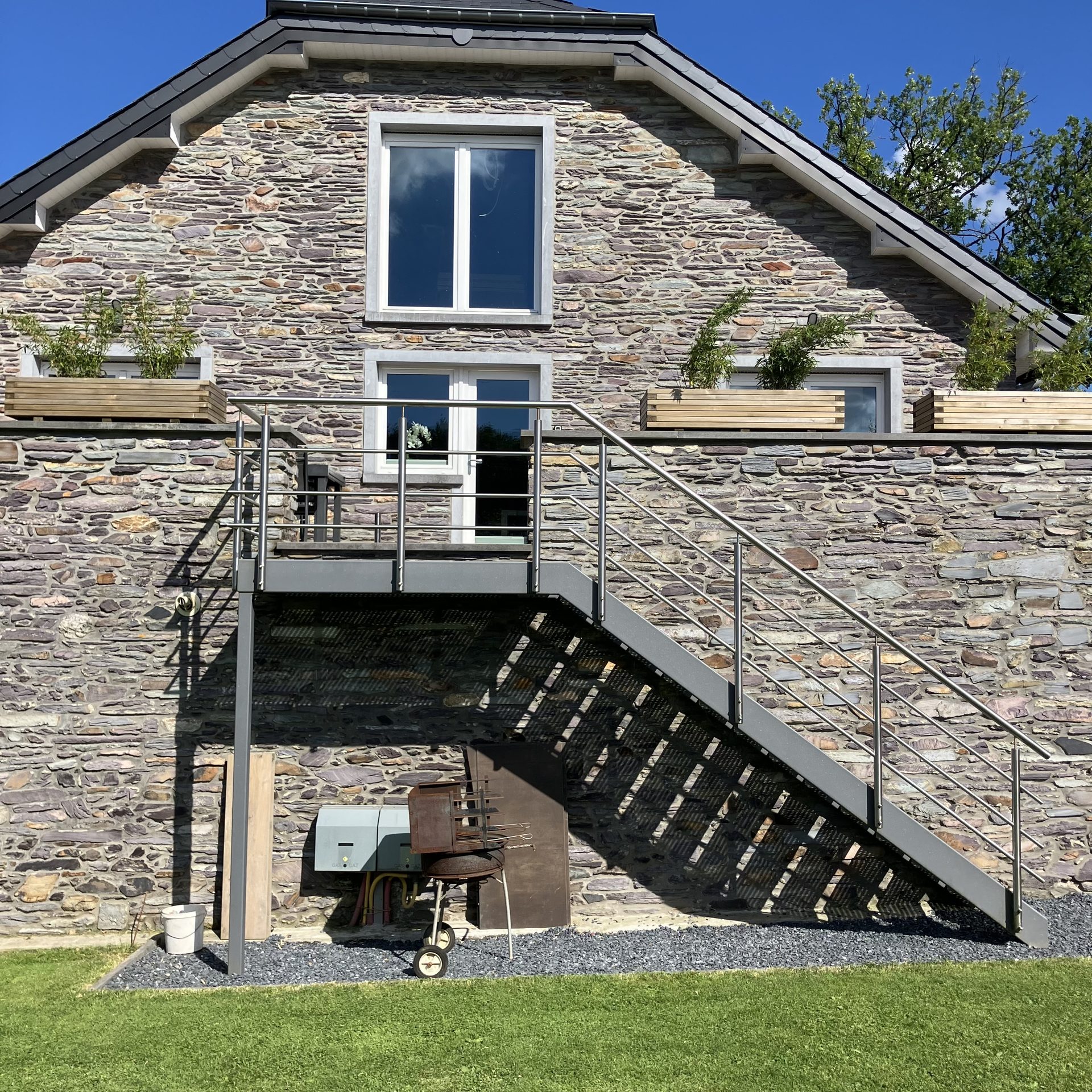Accès à l’appartement Pegasus I par l’escalier extérieur, le long de la façade en pierre